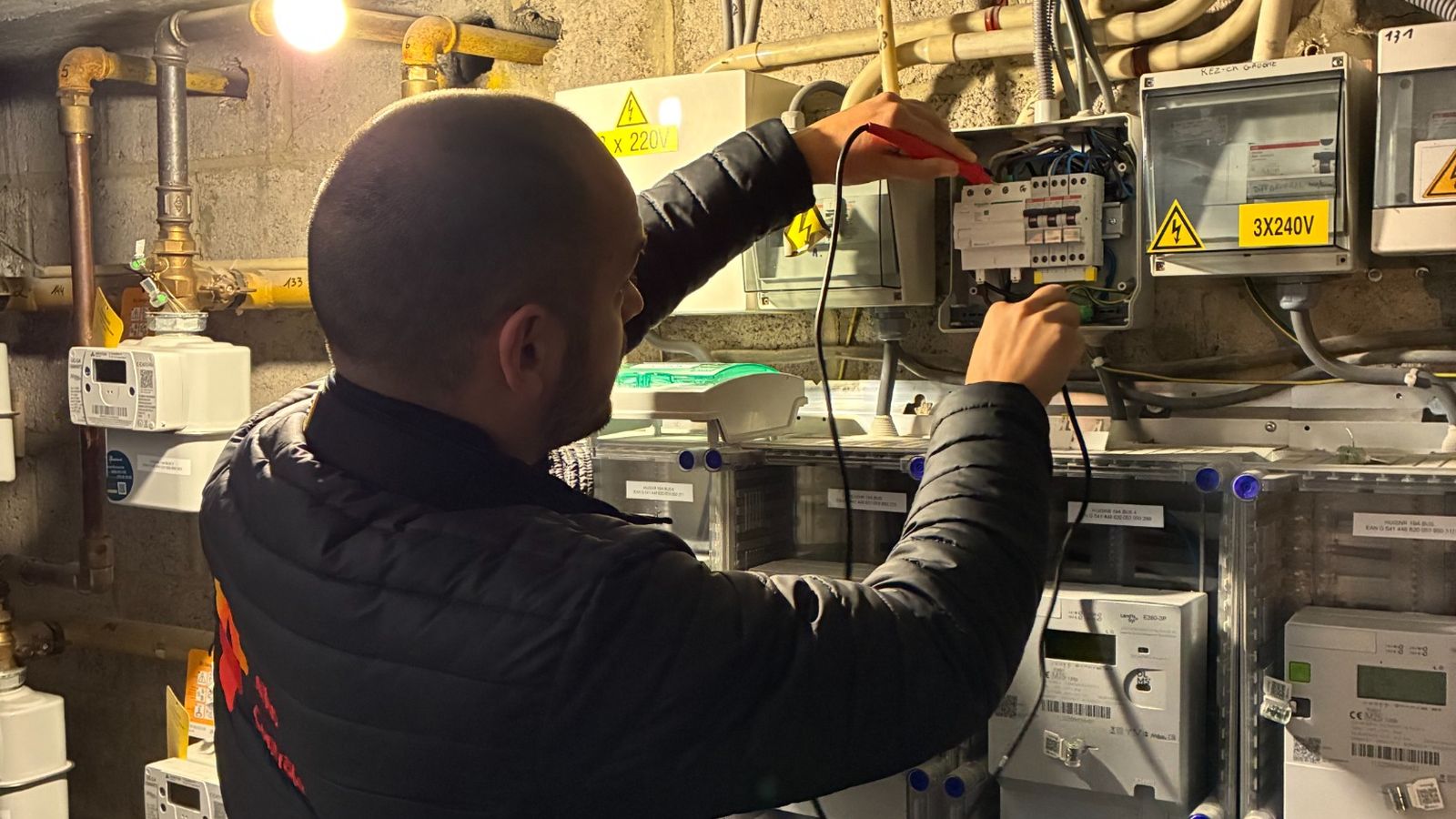 Contrôle électrique en Belgique : inspecteur Atlas Contrôle mesurant une installation au multimètre dans un local compteurs