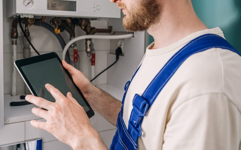 A,Repairman,Checks,A,Gas,Boiler,In,A,Bathroom,While